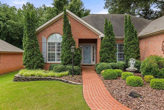  - view of front of property featuring brick siding and a front yard