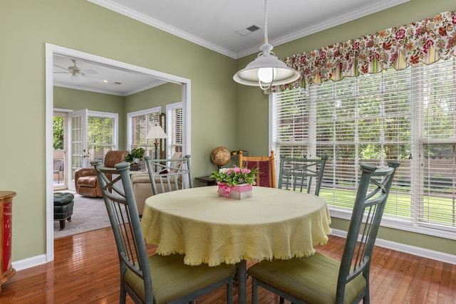  - dining space with a ceiling fan, wood finished floors, plenty of natural light, baseboards, and crown molding