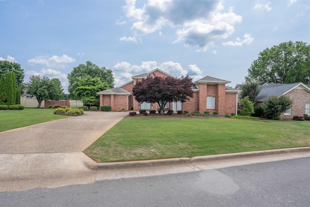  - view of front of home featuring concrete driveway, a front yard, and brick siding