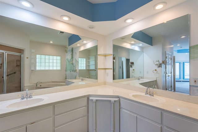  - bathroom featuring a stall shower, double vanity, recessed lighting, and a garden tub