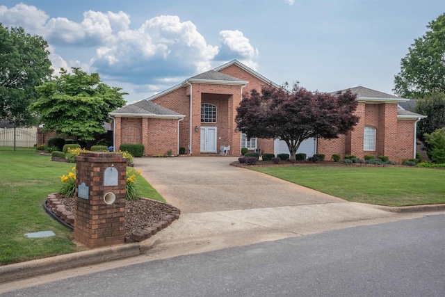  - view of front of home featuring brick siding, a front yard, and concrete driveway