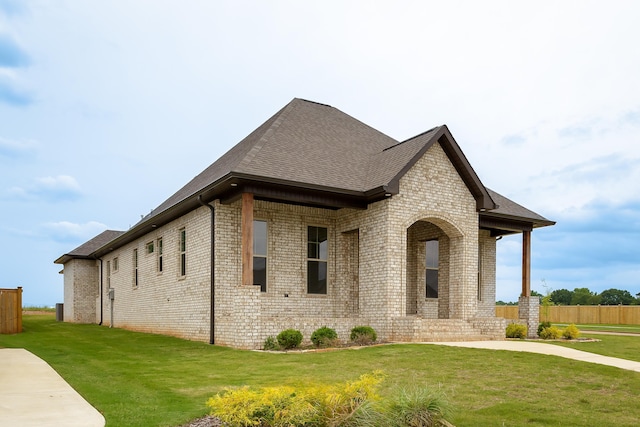 view of side of property with brick siding and a yard