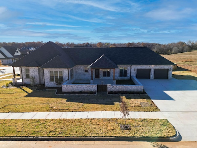 ranch-style house featuring a garage and a front lawn