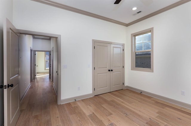 unfurnished bedroom with ceiling fan, light hardwood / wood-style floors, crown molding, and a closet