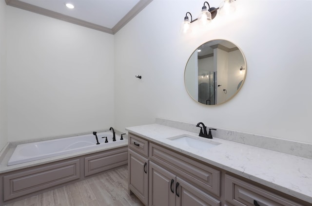 bathroom featuring hardwood / wood-style floors, vanity, a tub to relax in, and crown molding