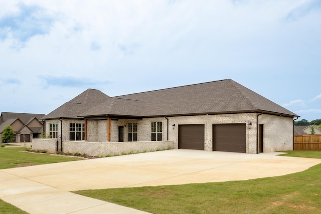 view of front facade featuring brick siding, concrete driveway, roof with shingles, a front yard, and an attached garage