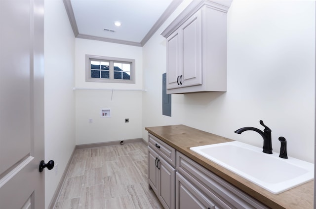 clothes washing area with sink, cabinets, electric dryer hookup, crown molding, and hookup for a washing machine