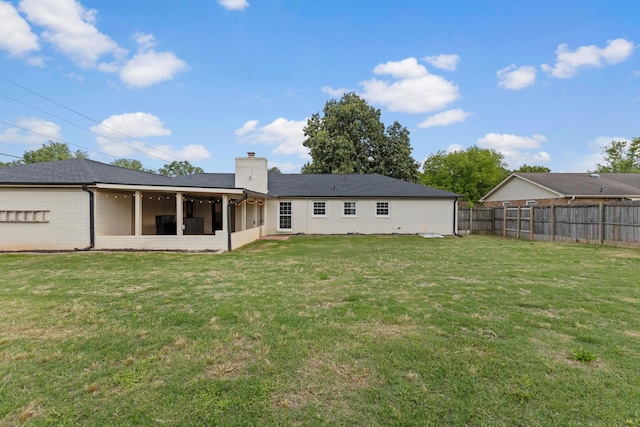  - rear view of house with a chimney, a sunroom, and brick siding