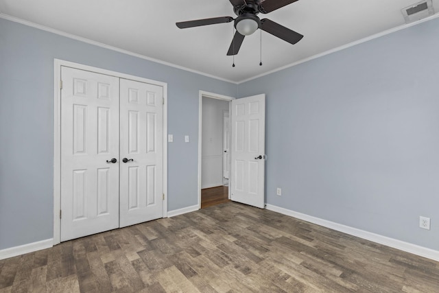  - unfurnished bedroom with wood finished floors, crown molding, baseboards, a closet, and ceiling fan