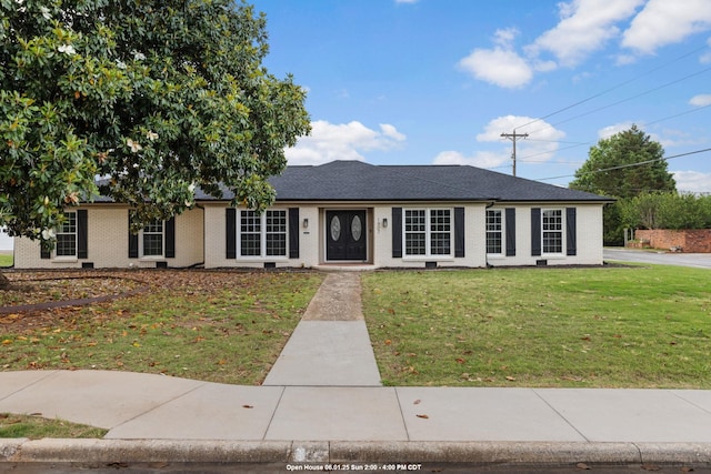 - ranch-style home featuring brick siding and a front yard