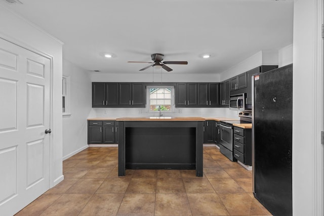  - kitchen with stainless steel appliances, a ceiling fan, a sink, dark cabinets, and wooden counters