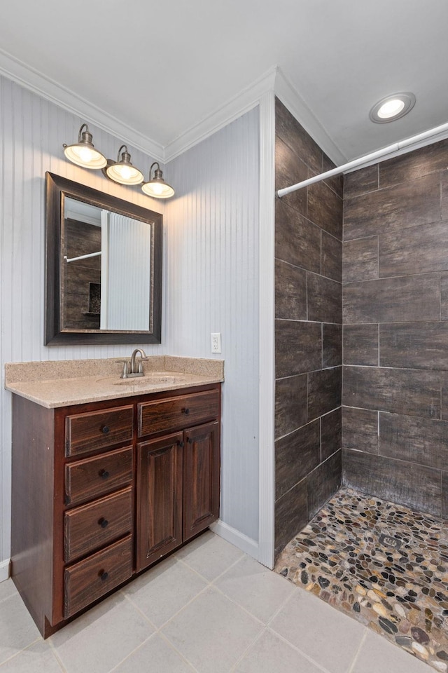  - bathroom with vanity, a tile shower, baseboards, tile patterned floors, and crown molding