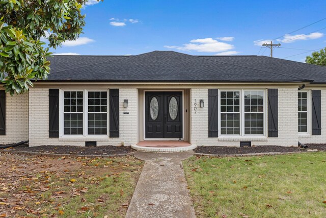  - ranch-style house featuring a shingled roof, brick siding, and a front yard