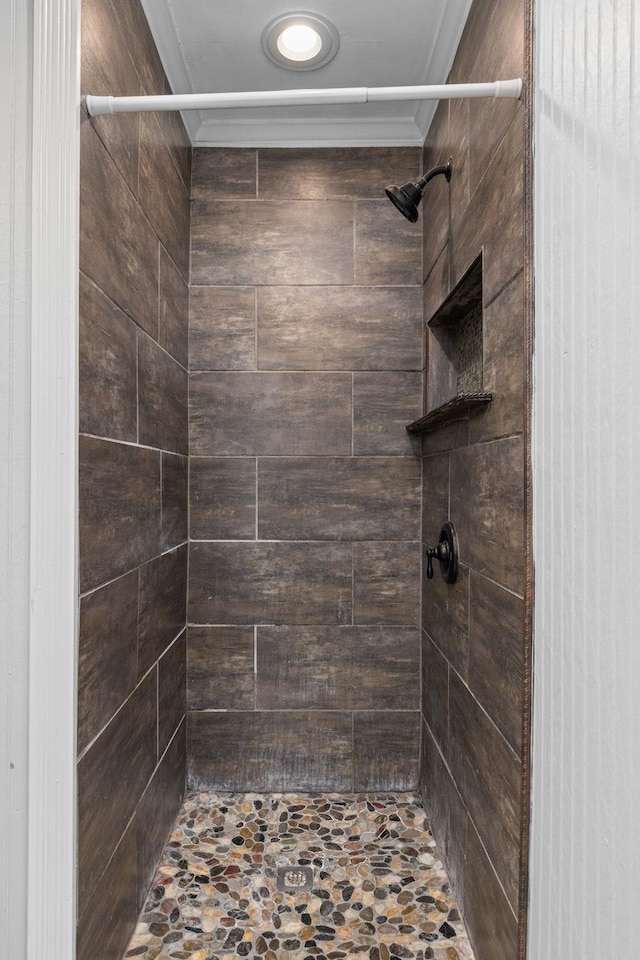  - full bath featuring ornamental molding and a tile shower