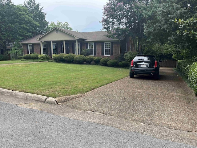  - ranch-style house featuring a front yard, brick siding, and concrete driveway