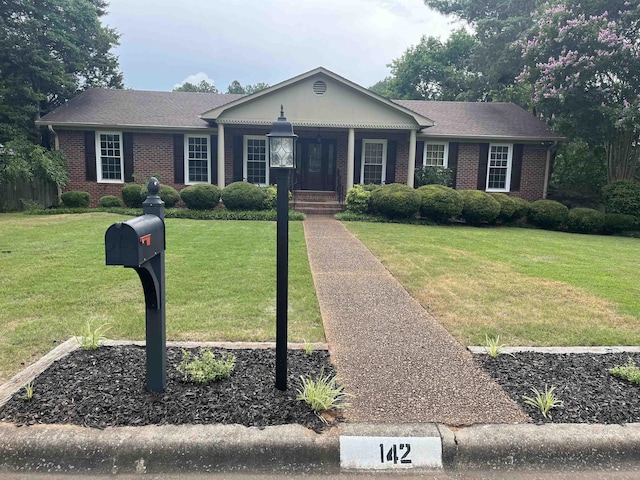  - ranch-style house with brick siding, a front yard, and covered porch