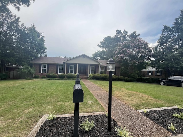  - view of front of home with a front yard and brick siding