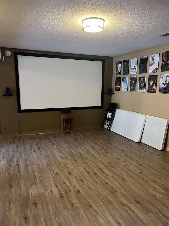  - cinema room featuring wood finished floors and a textured ceiling