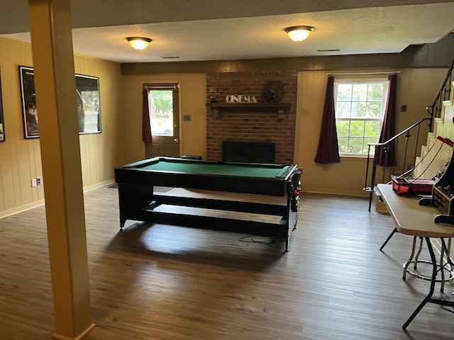  - playroom with wood finished floors, baseboards, billiards table, and a brick fireplace