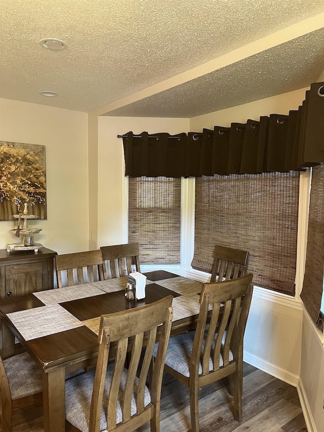  - dining area with wood finished floors and a textured ceiling