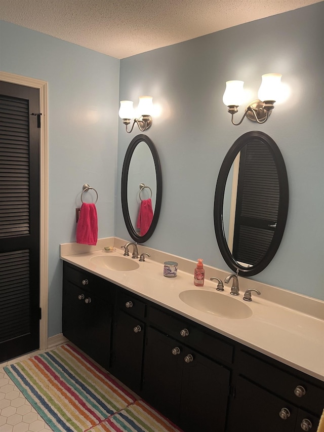  - full bathroom with double vanity and a textured ceiling