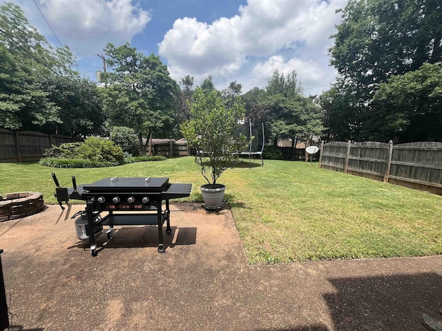 - view of yard featuring a trampoline, a patio, and an outdoor fire pit