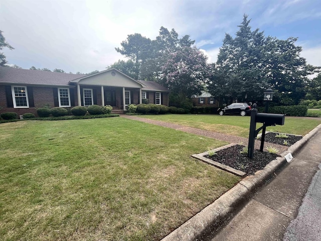  - view of front of home featuring a front yard, a porch, and brick siding