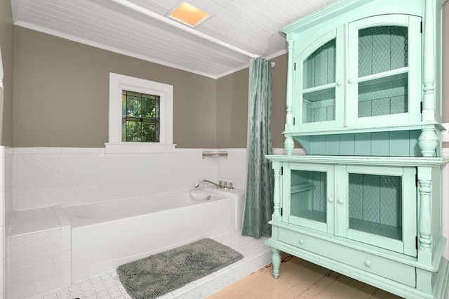  - bathroom with a garden tub, ornamental molding, a wainscoted wall, and tile walls