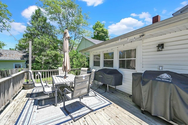  - wooden terrace featuring outdoor dining space and a grill