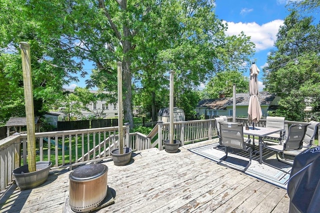  - wooden deck with a storage shed, an outbuilding, outdoor dining area, and a fenced backyard