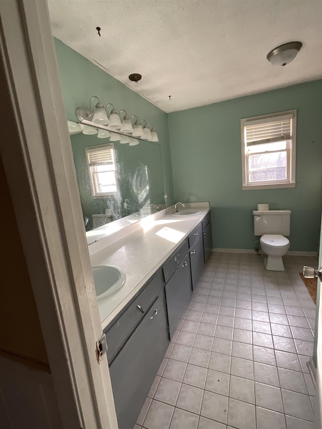 bathroom featuring vanity, tile patterned floors, toilet, and a textured ceiling