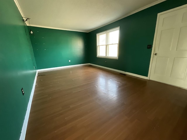 spare room with hardwood / wood-style flooring and crown molding