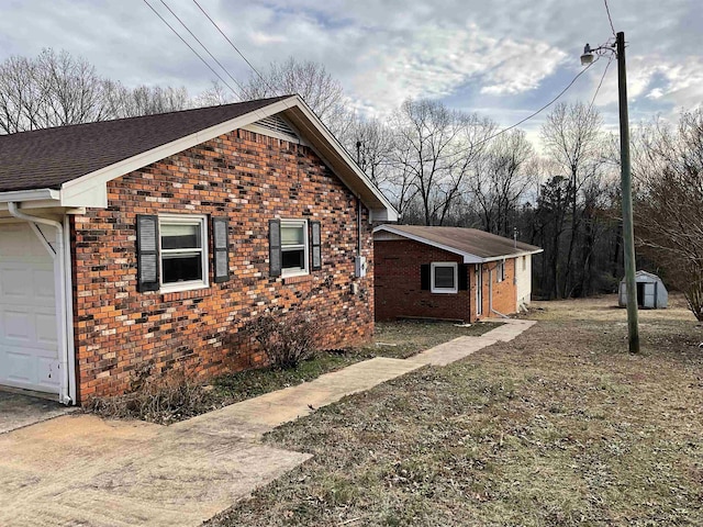 view of side of home featuring a garage and a storage unit