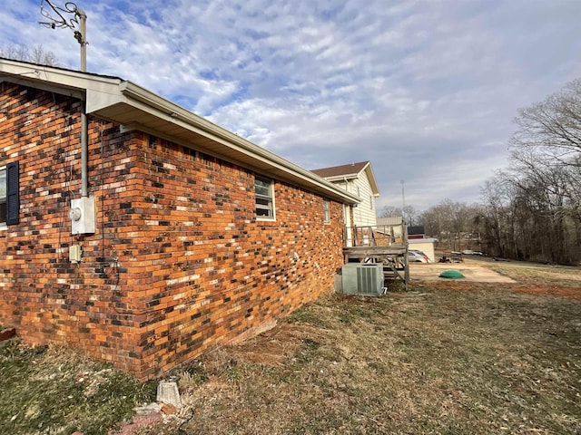 view of side of property with a lawn and central air condition unit