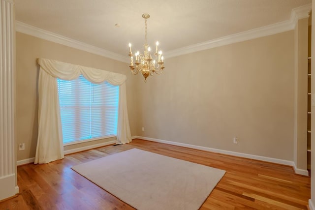 empty room with hardwood / wood-style floors, an inviting chandelier, and ornamental molding