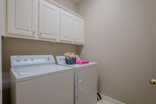 washroom featuring washer and clothes dryer and cabinets