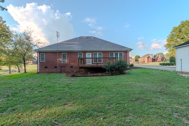 back of property with a lawn and a deck