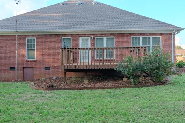 rear view of house with a wooden deck and a lawn