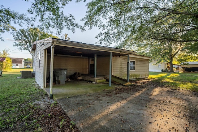 exterior space featuring a yard, central AC unit, and a carport