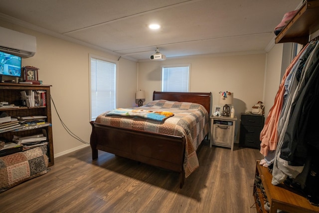 bedroom featuring a wall mounted air conditioner, dark hardwood / wood-style flooring, and ornamental molding