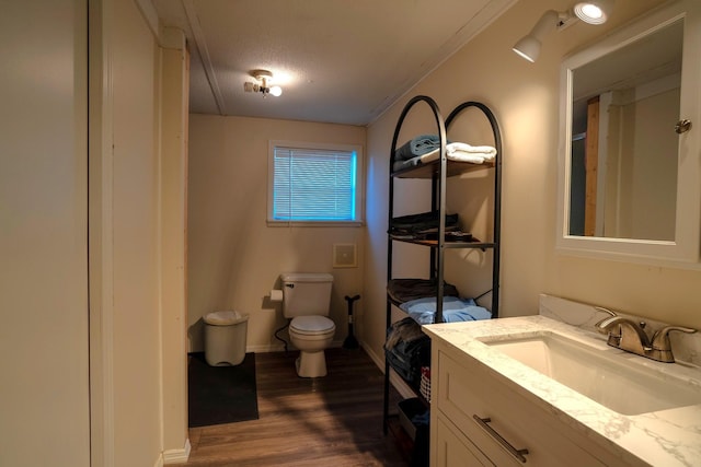 bathroom with hardwood / wood-style flooring, vanity, toilet, and a textured ceiling