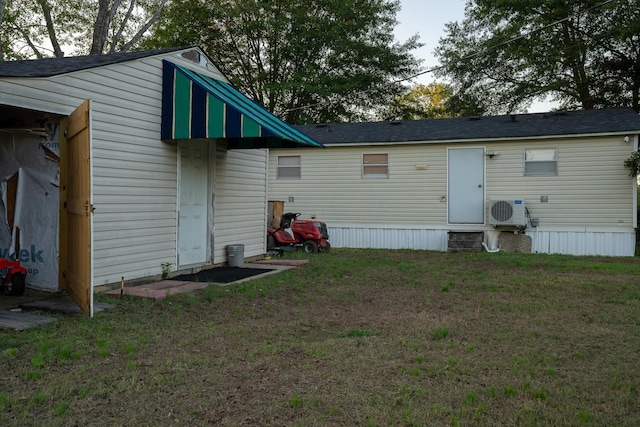 rear view of house with a lawn and ac unit