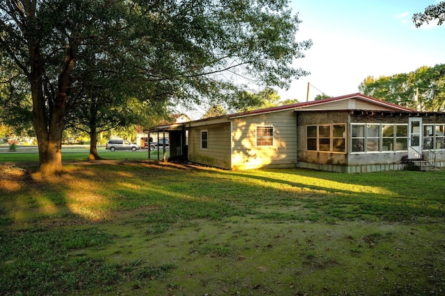 exterior space featuring a sunroom and a yard