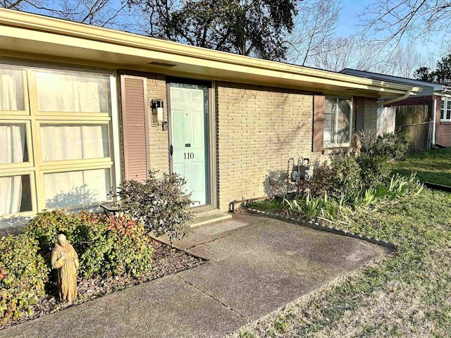 entrance to property featuring brick siding