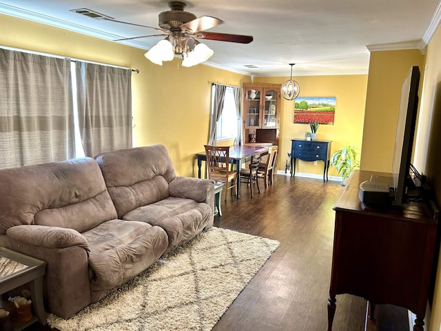 living area with wood finished floors, visible vents, baseboards, crown molding, and ceiling fan with notable chandelier