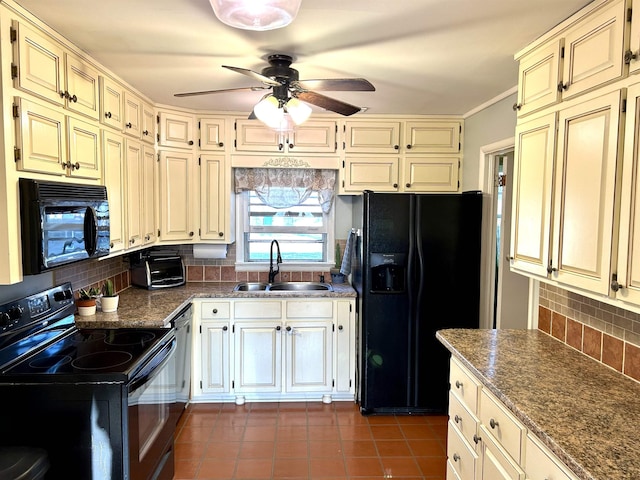 kitchen featuring a sink, cream cabinetry, backsplash, and black appliances