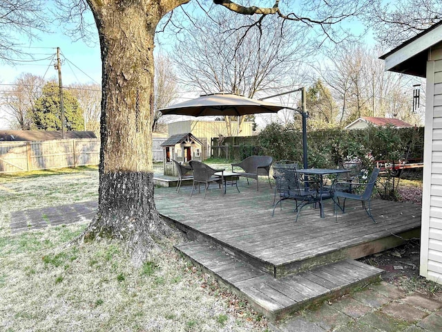 wooden deck featuring outdoor dining area and a fenced backyard