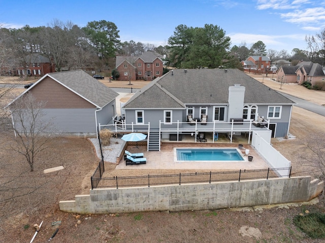 back of house with a pool side deck and a patio