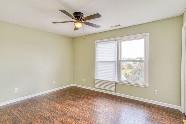 spare room with dark hardwood / wood-style floors, ceiling fan, and a healthy amount of sunlight