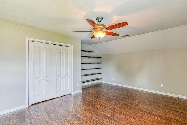 unfurnished bedroom with ceiling fan, dark hardwood / wood-style floors, lofted ceiling, and a closet